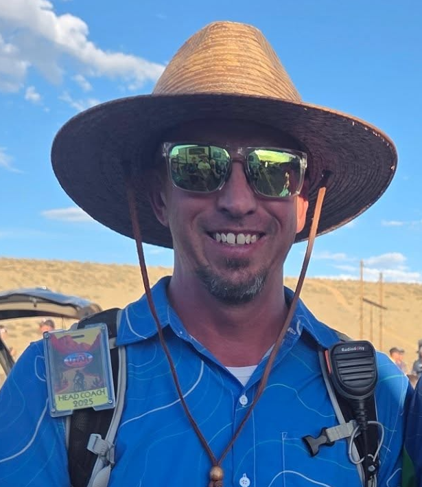 A photo of Mike Ross, the head coach of the Ridgeline MTB Team. He is smiling and wearing a Ridgeline MTB team jersey.